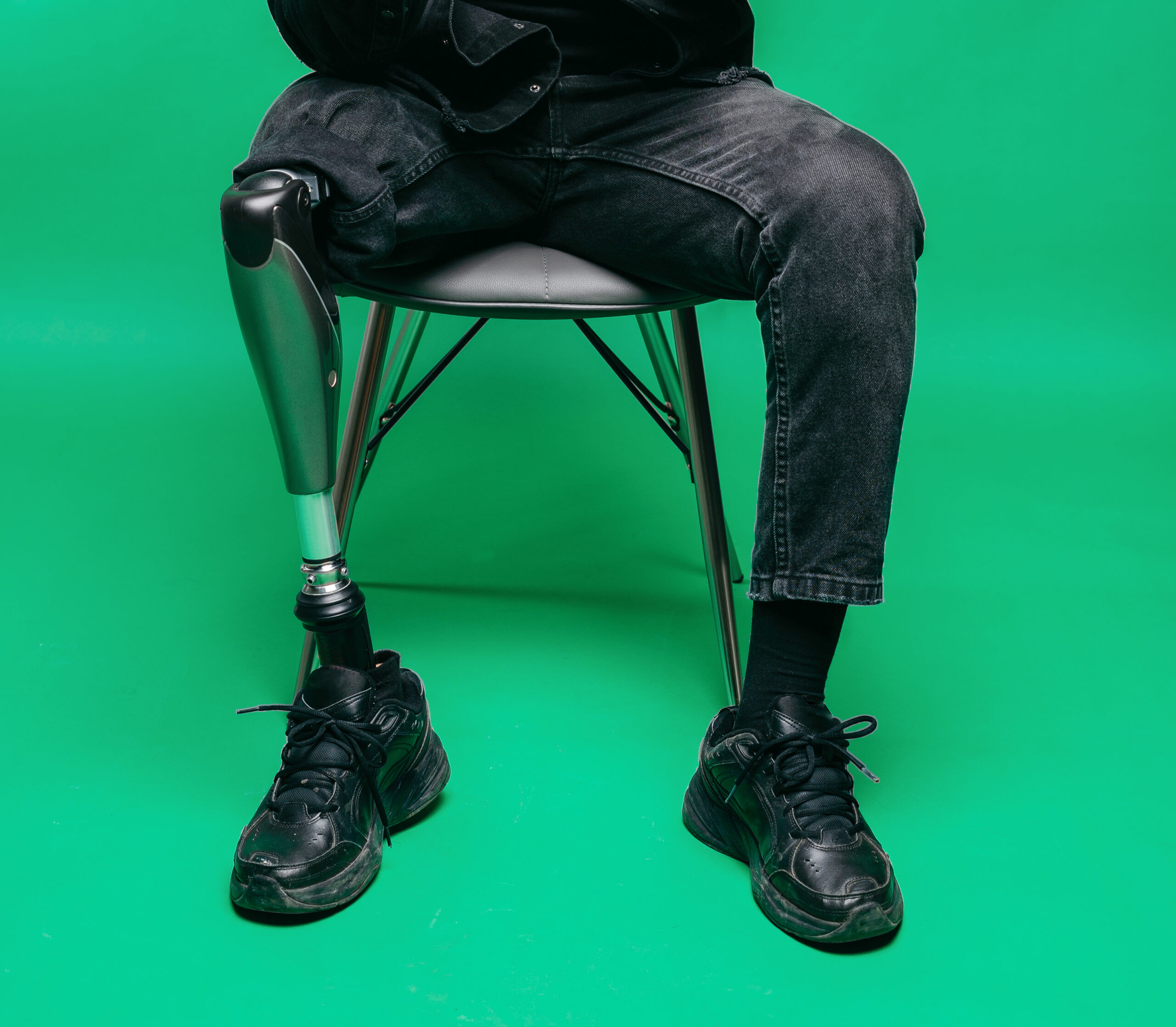 A man with a prosthetic leg sitting in a chair.
