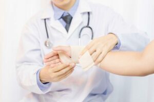 doctor wrapping a patients hand and wrist with a bandage