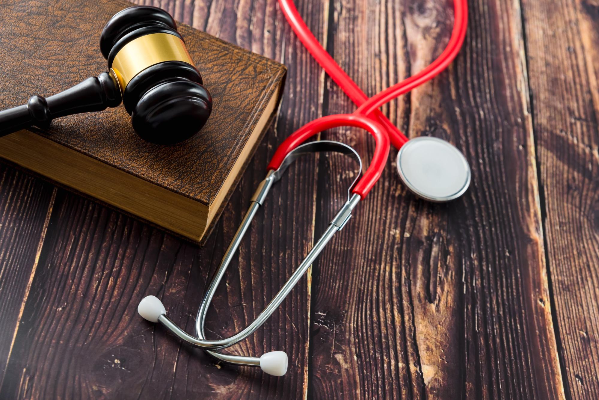 red stethoscope next to judges gavel symbolizing a medical malpractice lawsuit