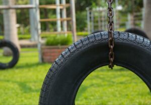 old tire swing held up by a chain at a daycare