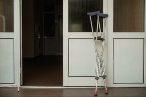 A pair of crutches leaning against a wall in a hospital room. People who suffer foot injuries in motorcycle accidents must deal with limited mobility after their accident.