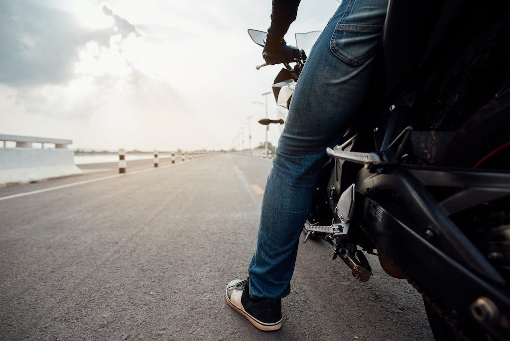 Motorcyclist wearing improper shoes for riding. Proper gear can help protect against foot injuries in a motorcycle accident.
