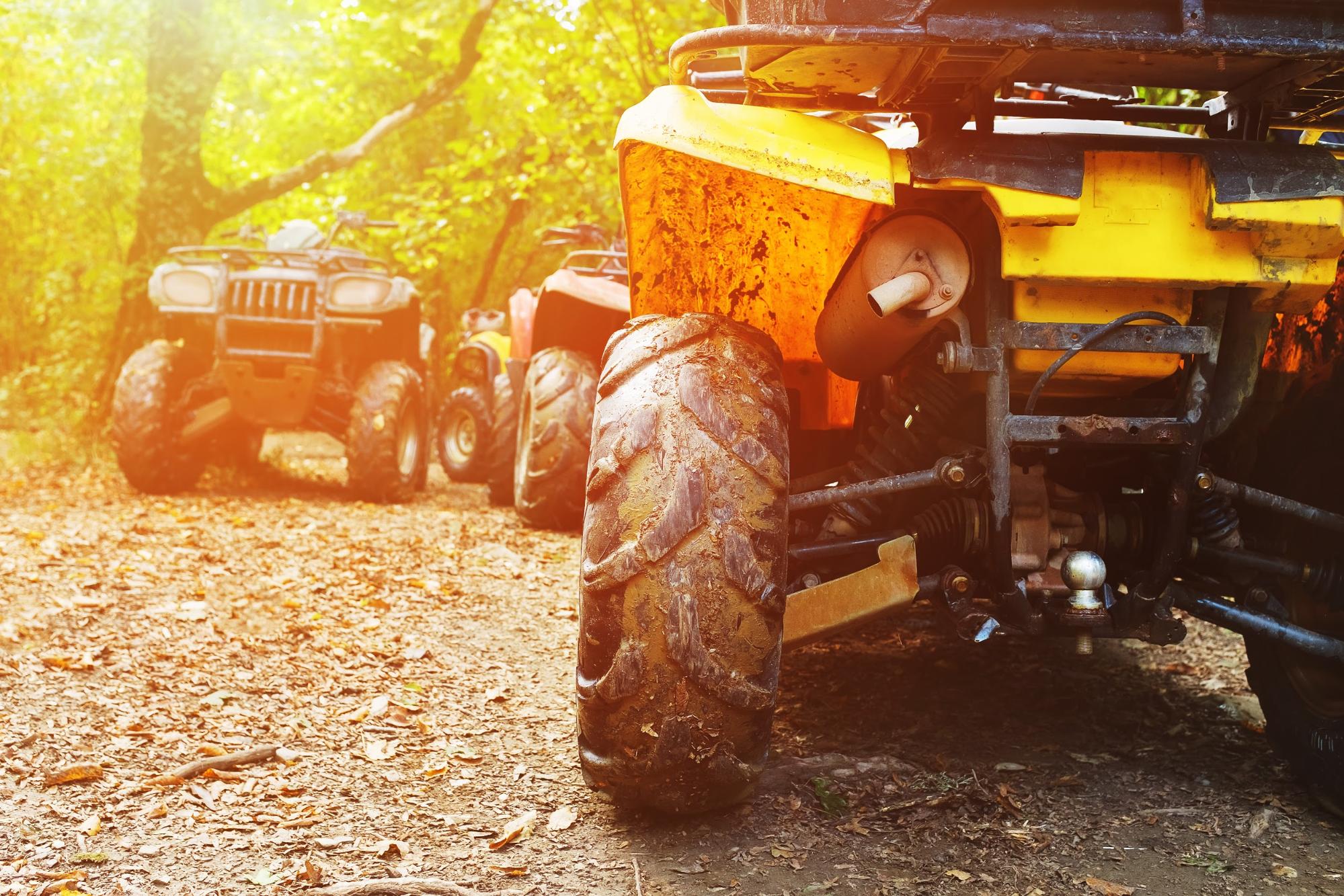 Parked ATVs at the end of a dirt trial in the woods. Following West Virginia's ATV laws can help keep riders safe while having fun on a trail.