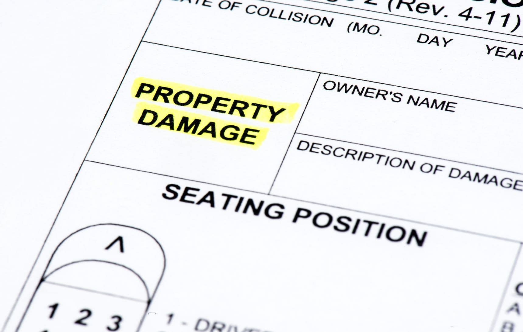 Close-up of a form showing the text "PROPERTY DAMAGE" highlighted in yellow. Nearby fields include "OWNER'S NAME" and "DESCRIPTION OF DAMAGE." Part of "SEATING POSITION" is visible.